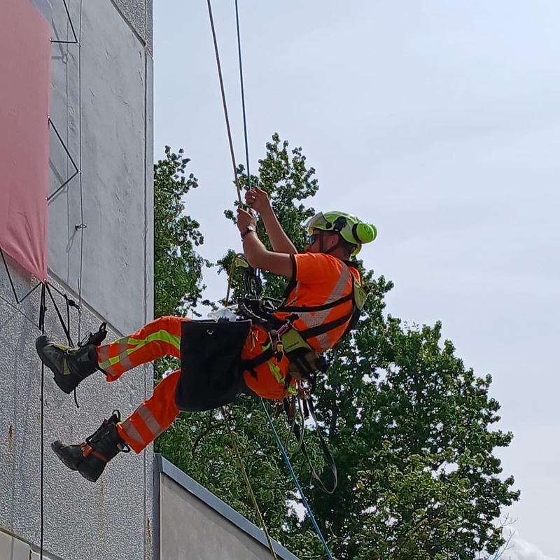Industriekletterer montiert Plane