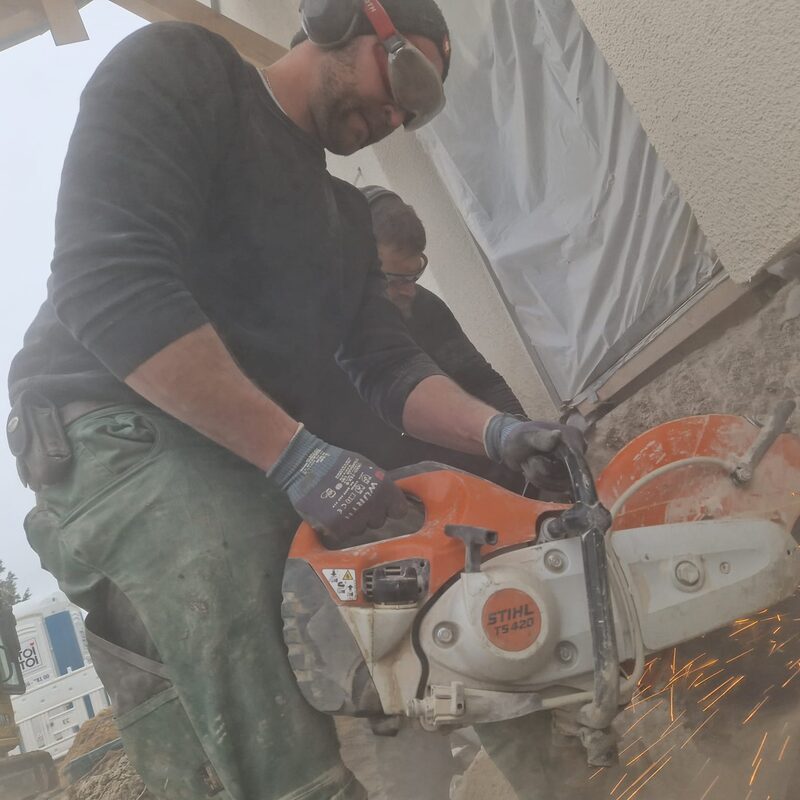 Handwerker mit Trennschleifer beim Schneiden von Stein