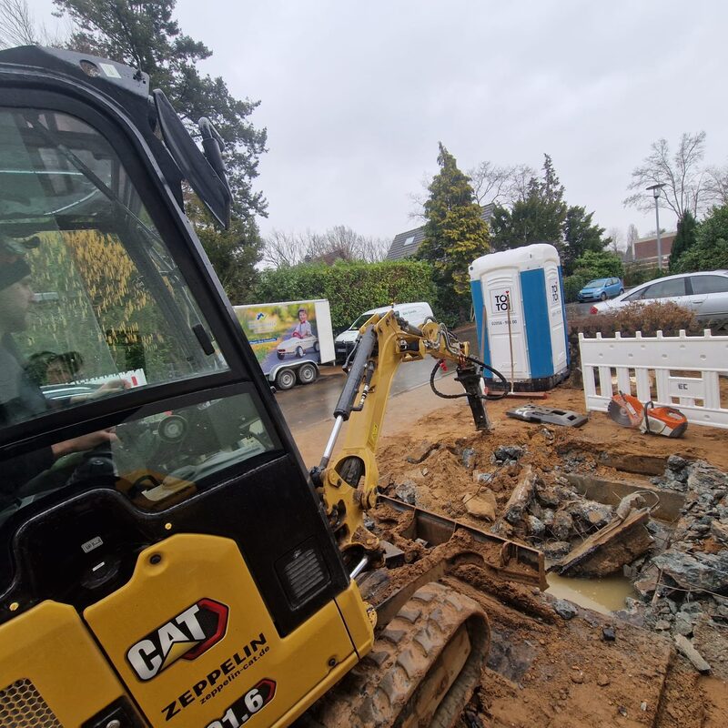 Baggerarbeiten auf Baustelle mit Bauschutt und Dixi-Klo