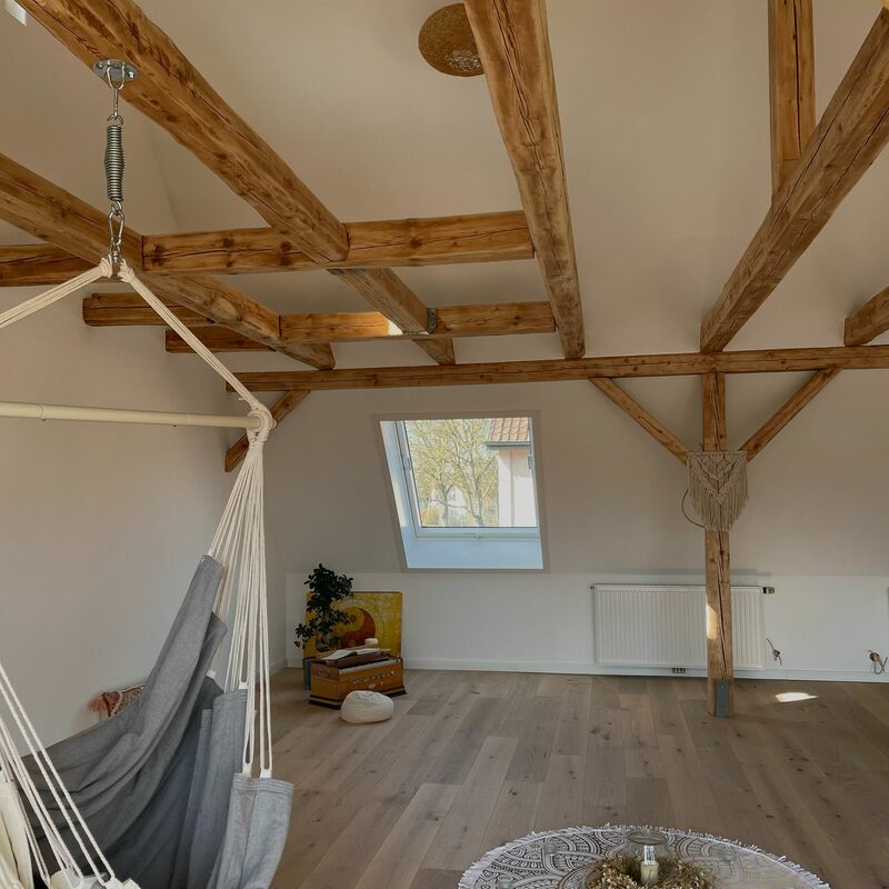 Yoga- und Meditationsraum mit Hängematte, Holzbalken und Fensterlicht