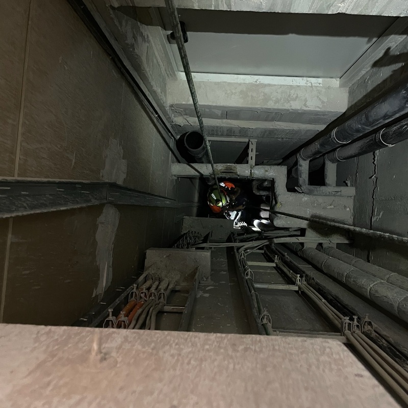 Arbeiter seilt sich im Versorgungsschacht ab