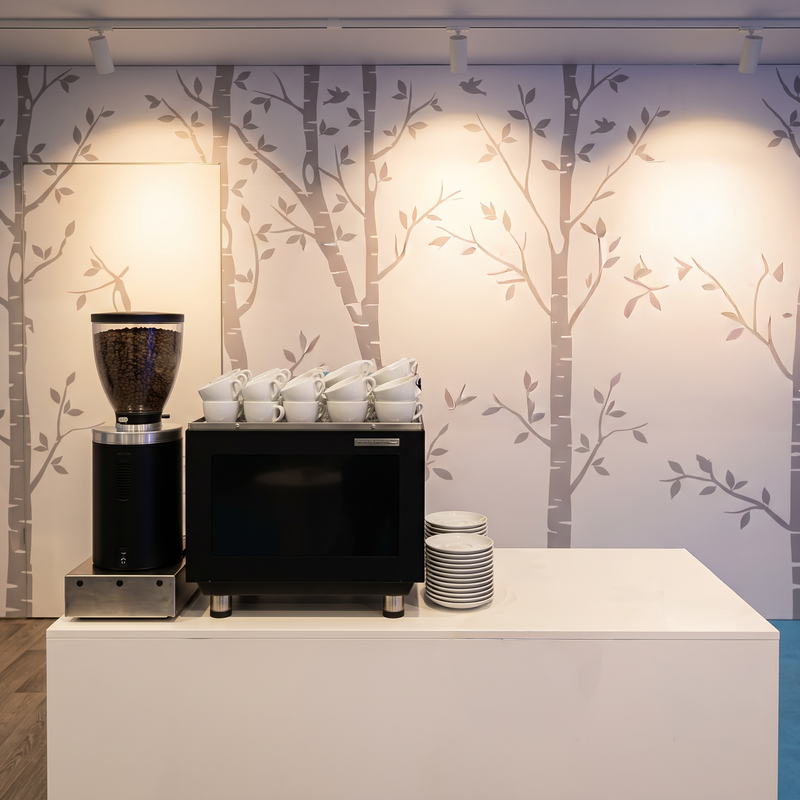 Zeitlos und elegant: Die SanRemo Zoe Compact auf unserer weißen Theke, ergänzt durch passendes Geschirr für einen professionellen Auftritt