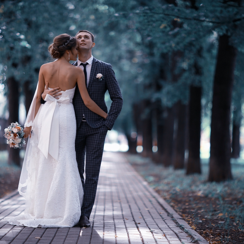 Brautpaar spaziert durch Allee in Berlin