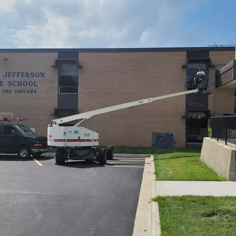 Repairing a window using the boom lift.