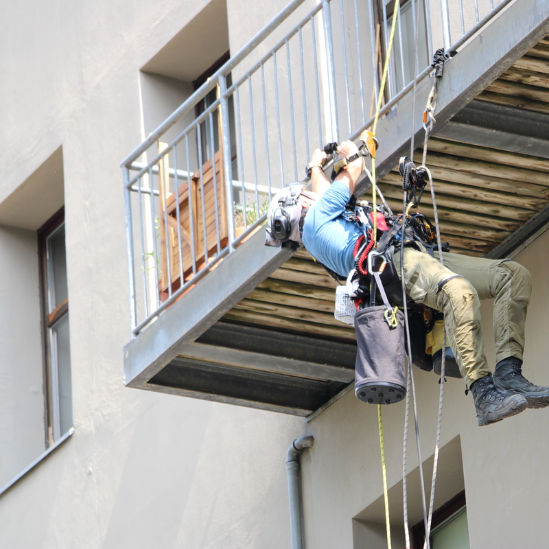 Seilarbeiter arbeitet unter Balkonboden