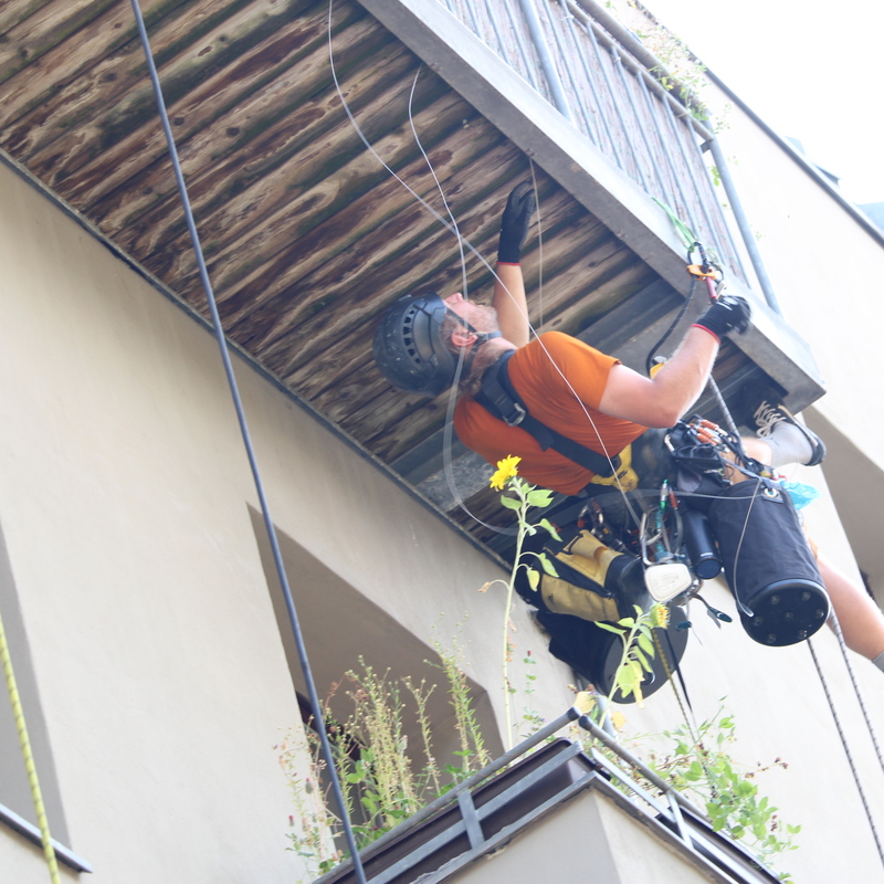 Kletterer arbeitet unter Balkon