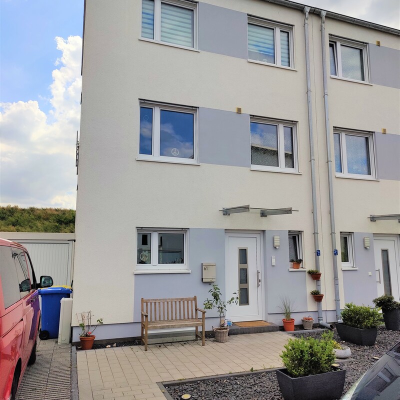 Moderne Doppelhaushälfte mit gepflastertem Vorgarten und Sitzbank