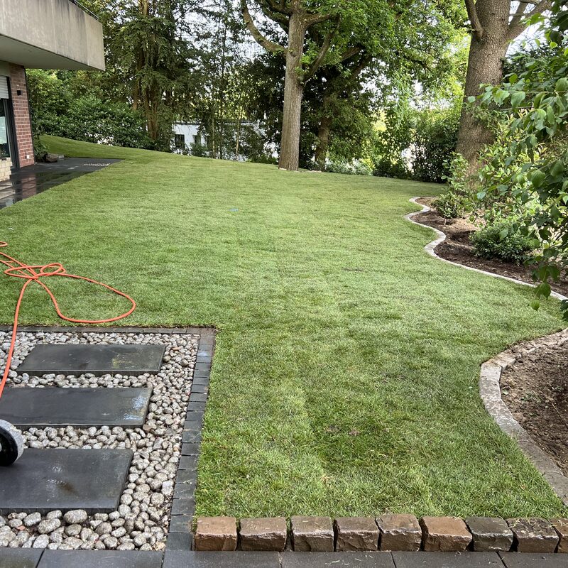 Rasenweg entlang eines Betonbeets mit Ausblick