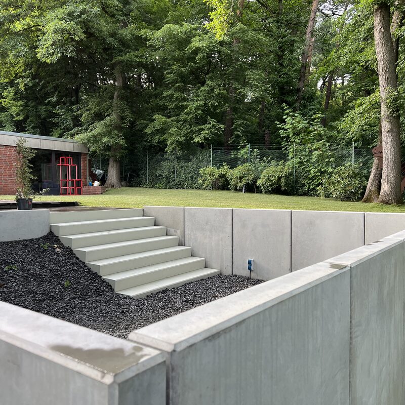 Gepflegter Rasen mit Bäumen und Pflanzfläche