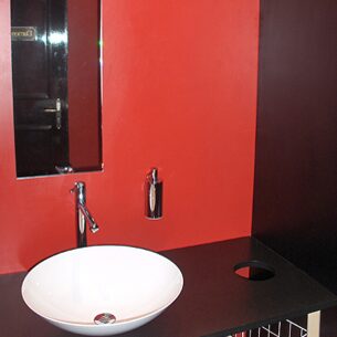  Waschbecken vor rot gestrichener Wand