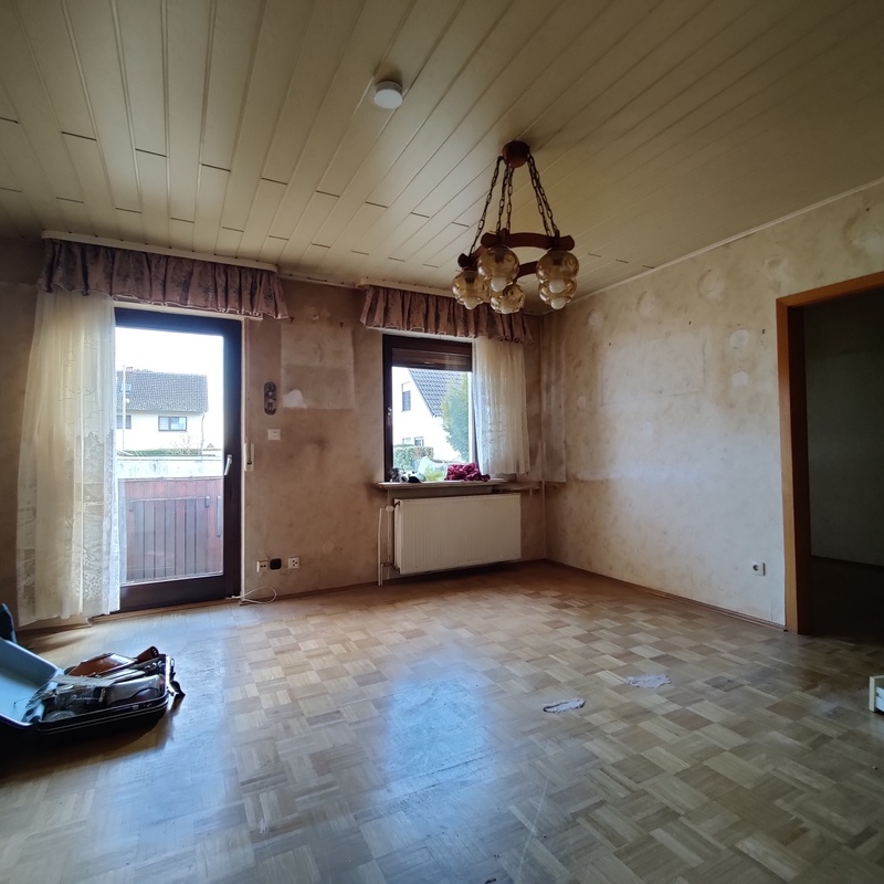 Wohnzimmer mit altem Parkettboden, Renovierungsbedarf sichtbar