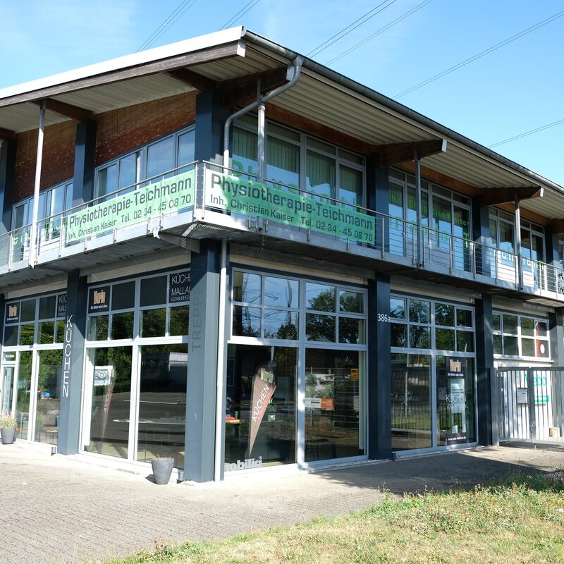 Außenansicht des Gebäudes mit Praxis Physiotherapie Teichmann und Balkonbeschriftung