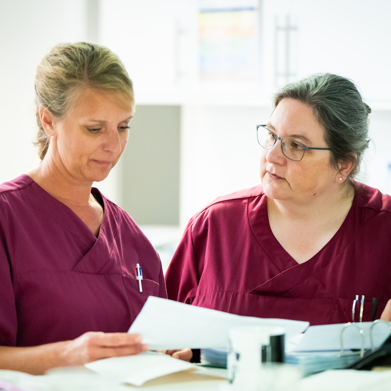 Teamarbeit am Schreibtisch mit Patientenunterlagen