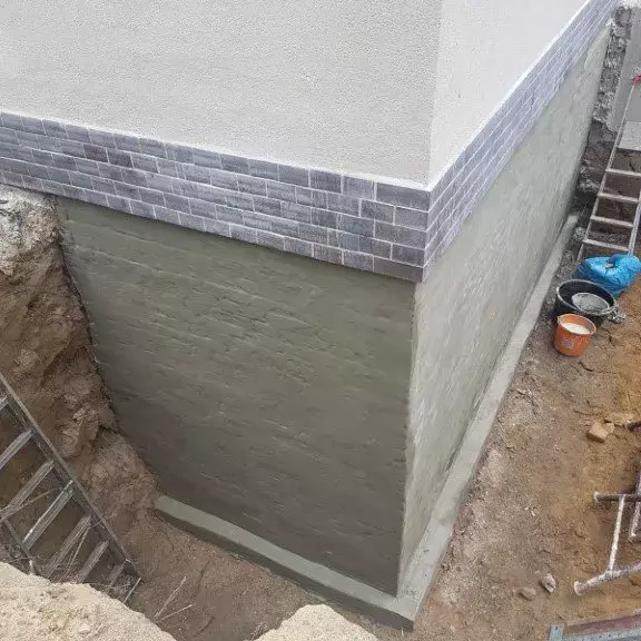 Außenabdichtung eines Mauerwerk. Aushub von Erde rund um das mauerwerk.