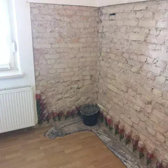 Fachgerechte Flächeninjektage zur Sanierung einer feuchten Hauswand, um Feuchtigkeit dauerhaft zu stoppen.