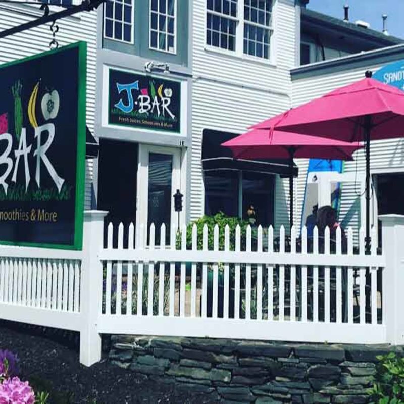 The exterior of J Bar in Harwich, showing patio and takout window