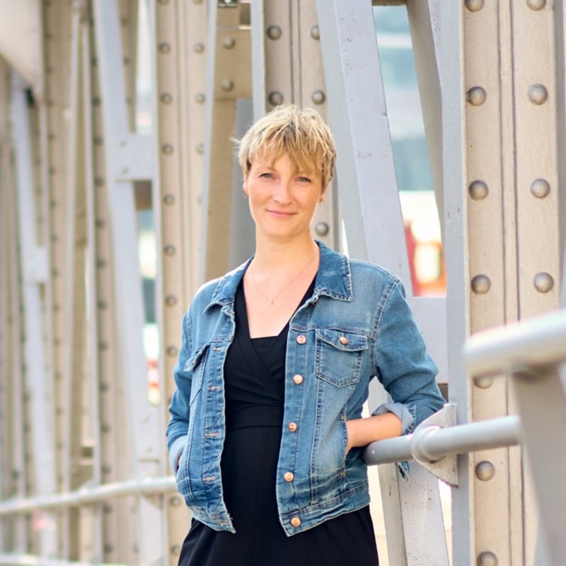 Frau mit Jeansjacke auf Brücke