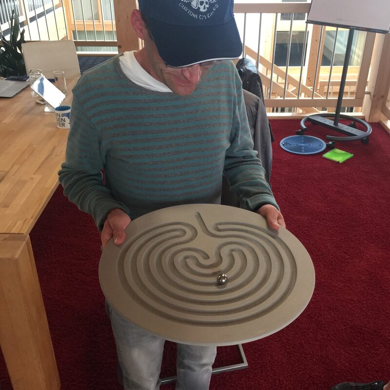 Mann balanciert eine Kugel in einem Labyrinthspiel