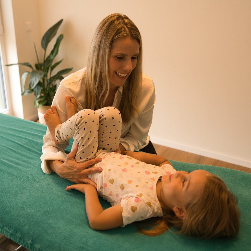 Therapeutin behandelt Kleinkind auf Liege