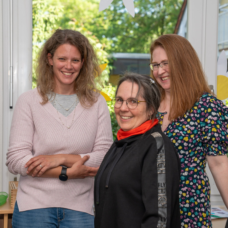 Lachende Mitarbeiterinnen im Gespräch im Gruppenraum