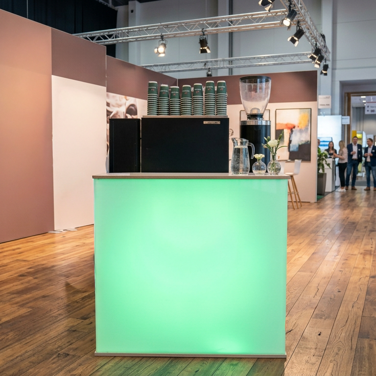 Unsere LED-Theke in Wunschfarbe, kombiniert mit der SanRemo Zoe Compact für einen professionellen und aufmerksamkeitsstarken Kaffeeauftritt