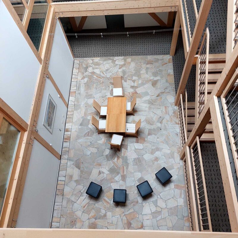 Luftaufnahme eines Innenhofs mit großem Tisch und Hockern