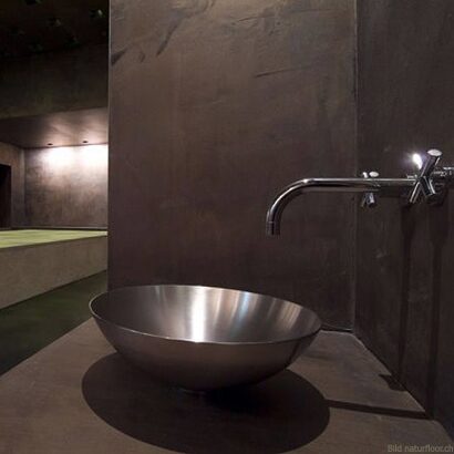 Dunkle Spachtelwand mit Edelstahlschale