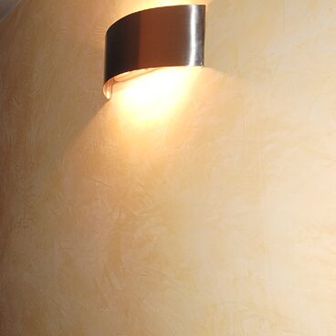 Gelbe Wand mit Strukturputz und Wandlampe