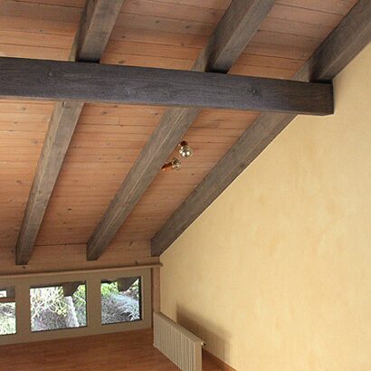 Dachgeschoss mit hell gestrichener Wand und Holzdecke