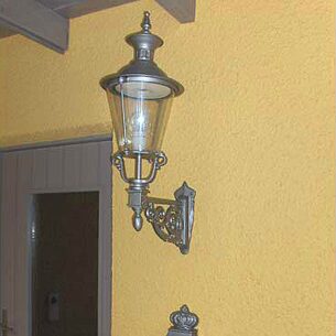 Gelbe Fassade mit Wandlampe und Briefkasten