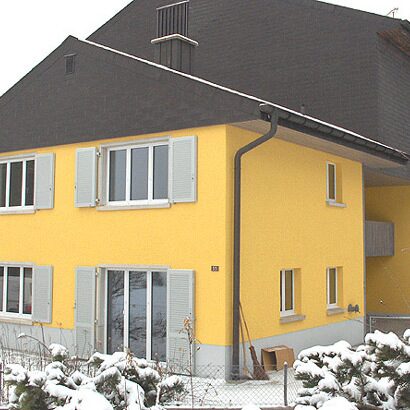 Haus mit gelber Fassade im Schnee