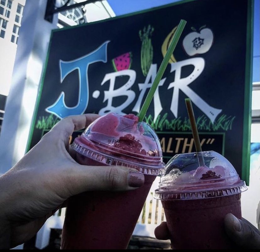 toasting with two smoothies in front of the J Bar sign in Harwich Port