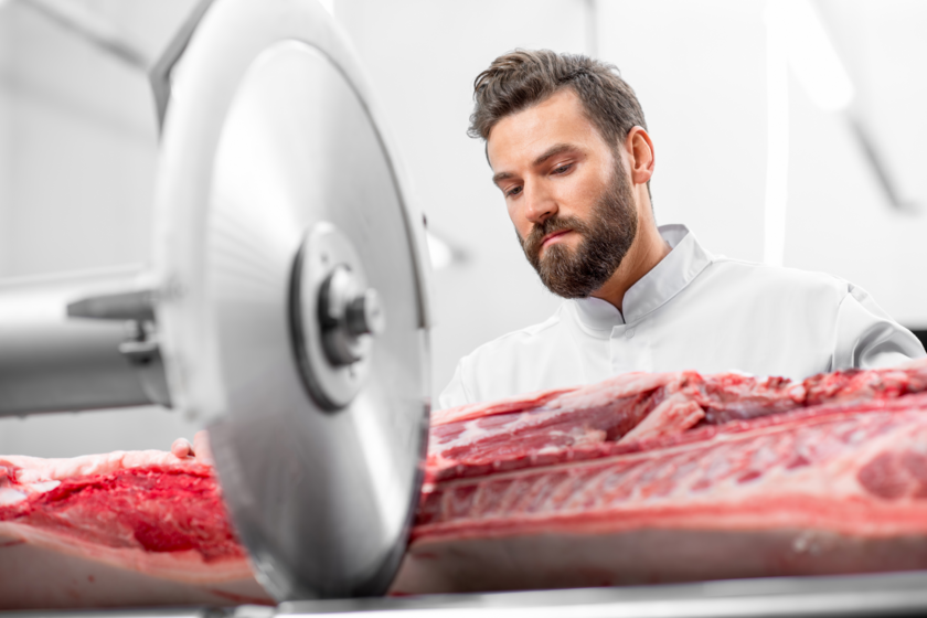 Metzger schneidet Fleisch an der Maschine