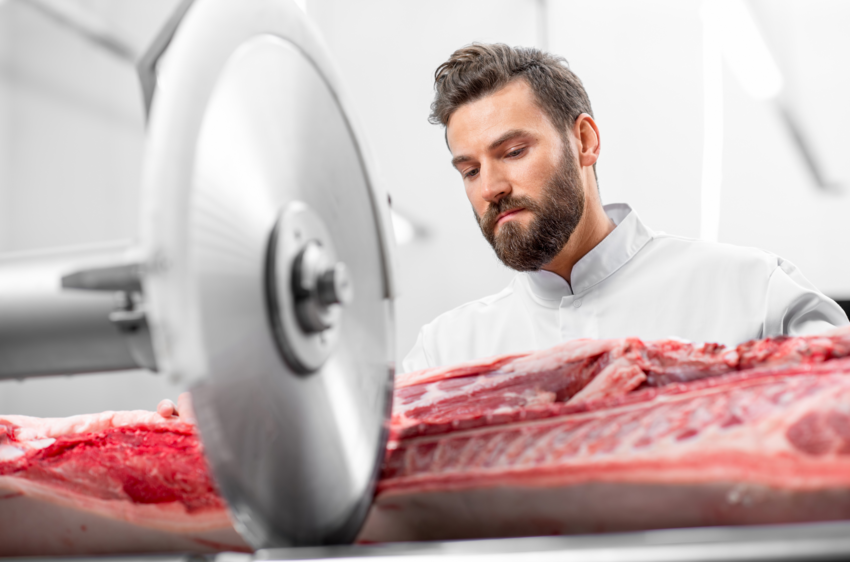 Metzger schneidet Fleisch an der Maschine