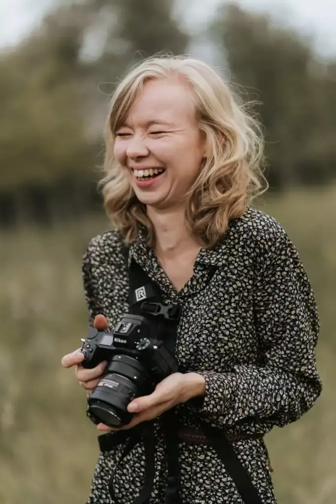 Die Fotografin Lisa Hambsch mit einer Kamera in der Hand. Sie ist Familienfotografin und Hochzeitsfotografin in Berlin