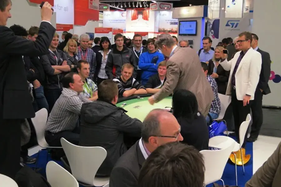 Große Besuchermenge am Casino-Tisch auf einer Messe – mobiles Casino mieten für Firmenevents