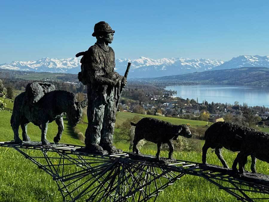 Figur eines Säumes vor einer wunderbaren Aussicht mit See und Alpen