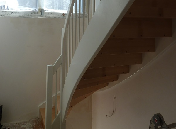 Renovierte Wendeltreppe von oben mit hellem Laminat in Eichenoptik und weißem Metallgeländer – Treppenrenovierung im Rhein-Main-Gebiet
