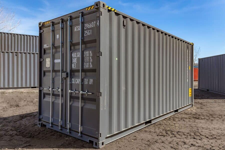 A grey 20 HC shipping container sitting in a parking lot.