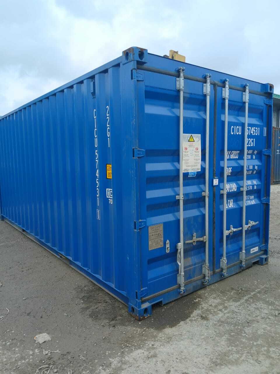 A grey 20 DV shipping container sitting in a parking lot