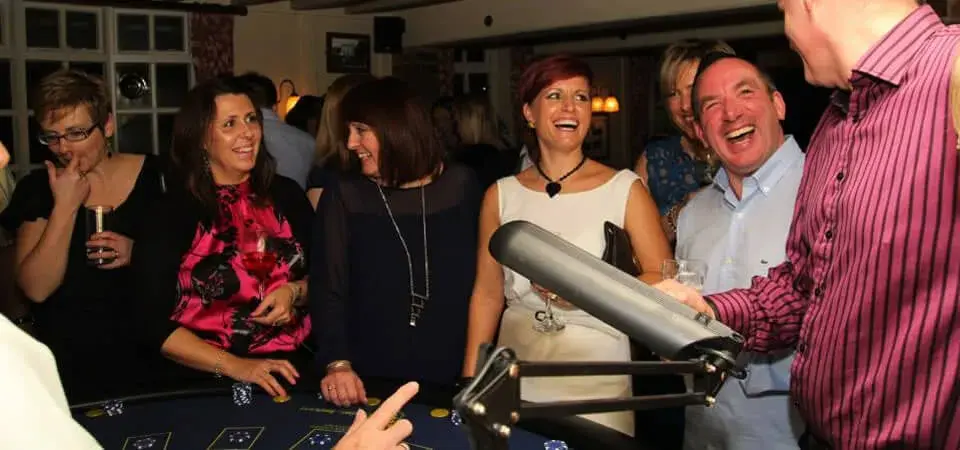 Drei lachende Frauen am Roulette-Tisch bei einem unterhaltsamen Casino-Event